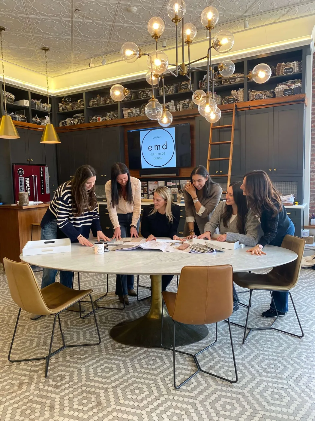 The Ellie Mroz Design team collaborating around the studio table in Westfield, NJ