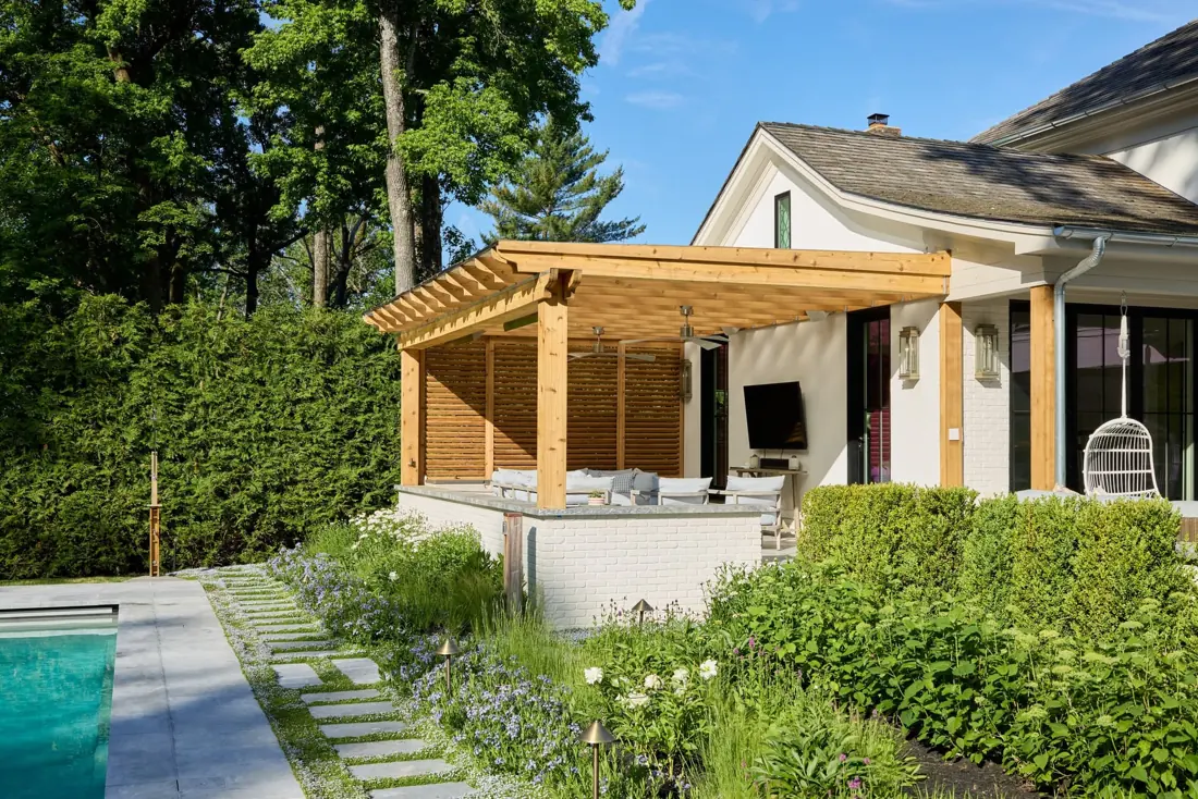 Cedar pergola sheltering an outdoor lounge beside a Westfield home